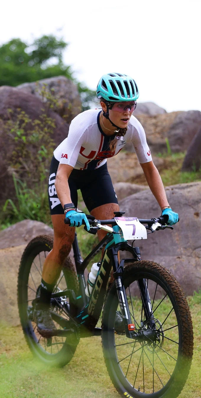 Kate Courtney ciclando en una bicicleta de montaña sobre un cerro.