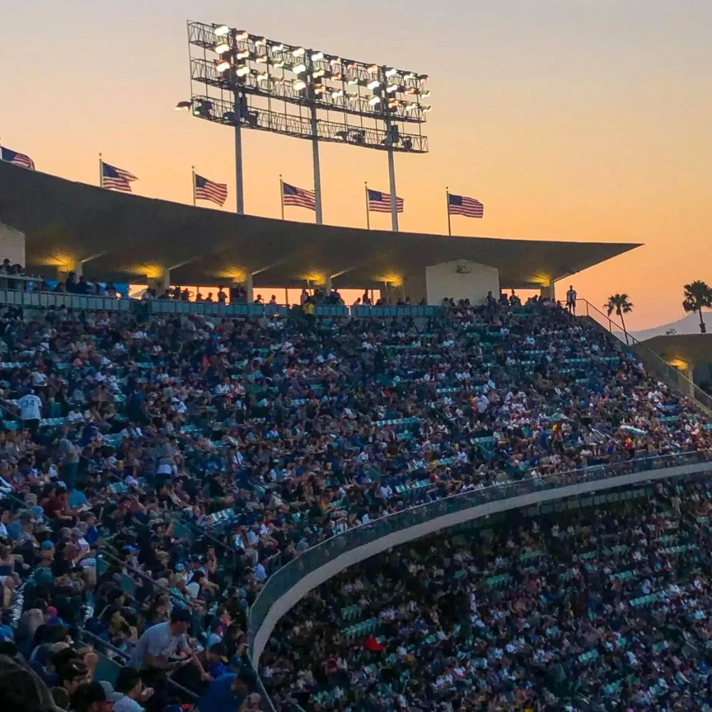 Fotografía de un estadio lleno con miles de personas durante el atardecer