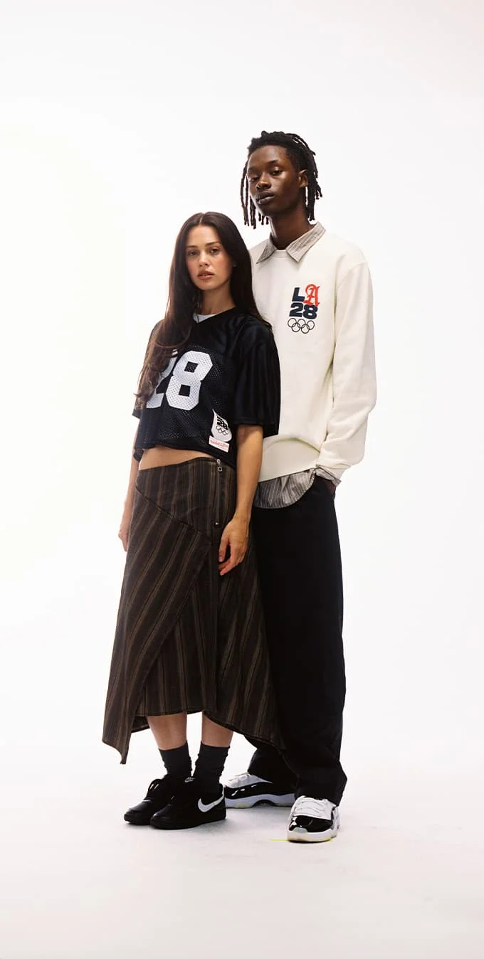 Photographs featuring a white hoodie from Mitchell & Ness with the words ‘Los Angeles and United States of America 2028’ on the left chest, an image of a female in a LA28 black jersey and a male with a white LA28 hoodie and an image to the right of a black hoodie with the LA28 Olympic emblem. 